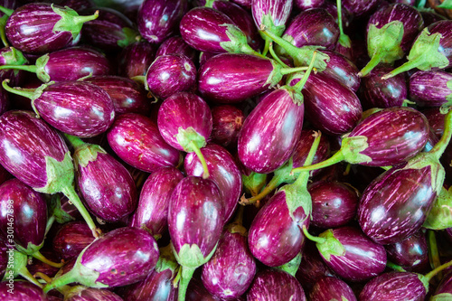 Egg plants beeing presented on the market. Sometimes they are displayed in baskets sometimes they are stacked. Lovely colors on these plants.