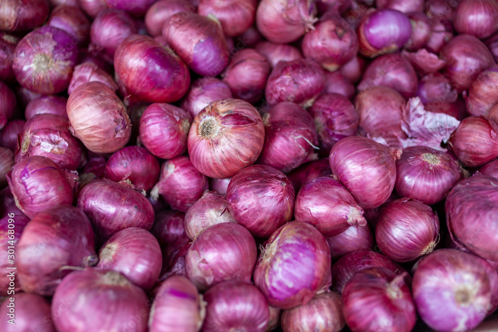 Red Onions are nicely stacked and piled up on this little market stand in Little India, Singapore. The red, purple color is very impressive.