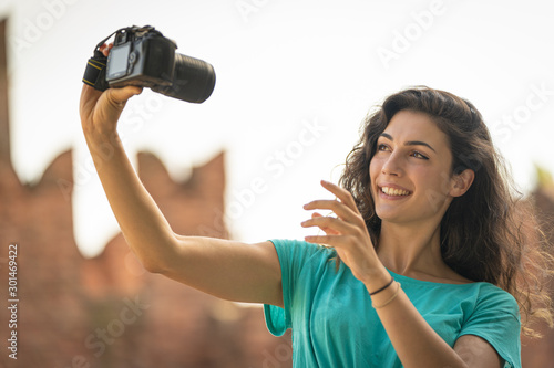 Girl taking a selfie with a big camera, old technology