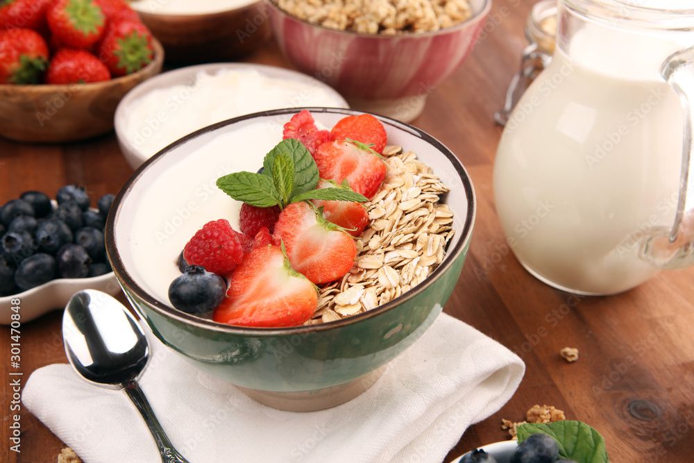 Tasty homemade granola served on table. Healthy breakfast with a bowl of oatmeal with banana, blueberries, strawberries and healthy food for Breakfast Tasty homemade granola served on table. Healthy breakfast with a bowl of oatmeal with banana, blueberries, strawberries and healthy food for Breakfast