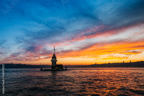 Fiery sunset over Bosphorus with famous Maiden's Tower (Kiz Kulesi) also known as Leander's Tower, symbol of Istanbul, Turkey. Scenic travel background for wallpaper or guide book © develi