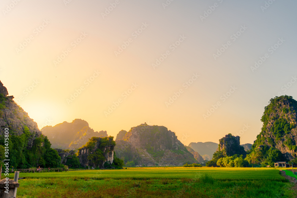 A stunning sunset over Hang Mua and the Mua Caves with limestone mountains in the background of Tam Coc, Ninh Binh, Northern Vietnam