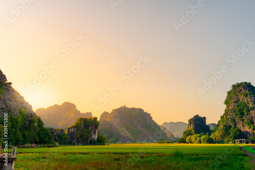 A stunning sunset over Hang Mua and the Mua Caves with limestone mountains in the background of Tam Coc, Ninh Binh, Northern Vietnam photo