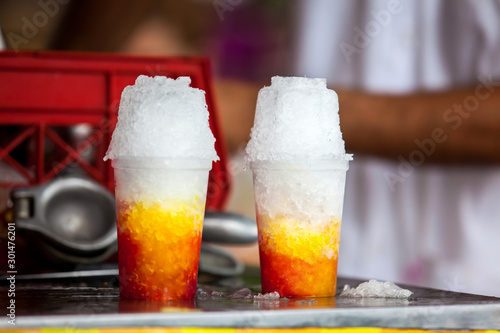 Street vendor in the city of Cali in Colombia preparing and selling a traditional sweet water ice called cholado photo