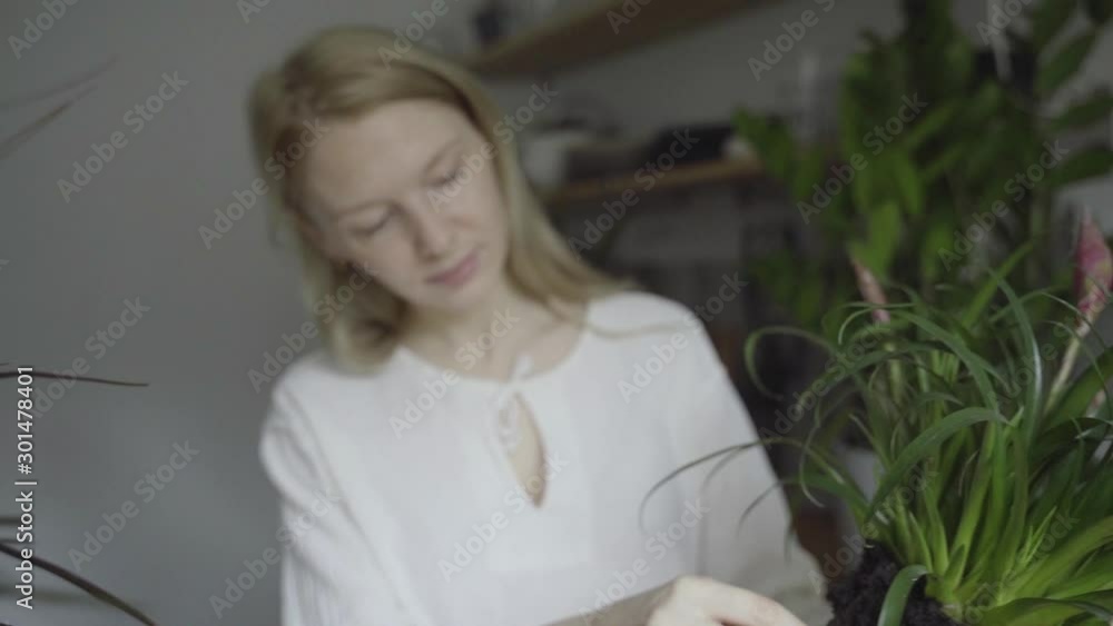 Young woman planting flowers in a pot . Young woman planting flowers in a pot .