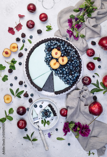 fresh blueberry tart with fruits on white conrete background photo