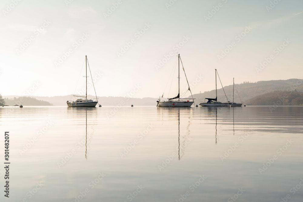 Early morning sunrise light boats on Lake Windermere in the English Lake District, UK
