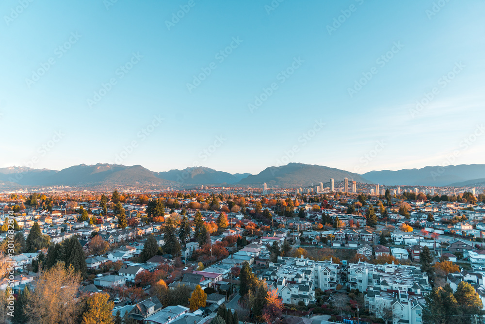 Fototapeta premium Autumn sunrise over the East Vancouver and view of downtown Brentwood, Burnaby with scenic mountains backdrop