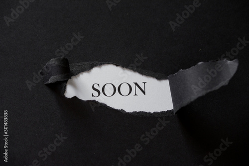 Torn paper box with word coming soon in low light