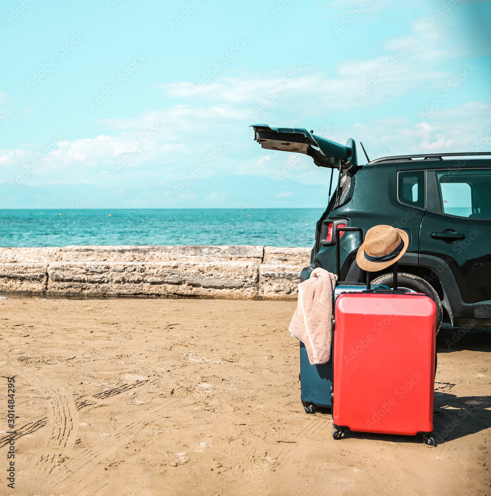 Black large car with an open luggage carrier parked on the beach. Sea landscape and free space for your product or text. Summer and sunny warm day. Copy space. Black large car with an open luggage carrier parked on the beach. Sea landscape and free space for your product or text. Summer and sunny warm day. Copy space.