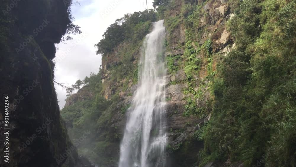 A handheld camera view of a chilly waterfall deep in the rainforest jungle ofter a long hike A handheld camera view of a chilly waterfall deep in the rainforest jungle ofter a long hike