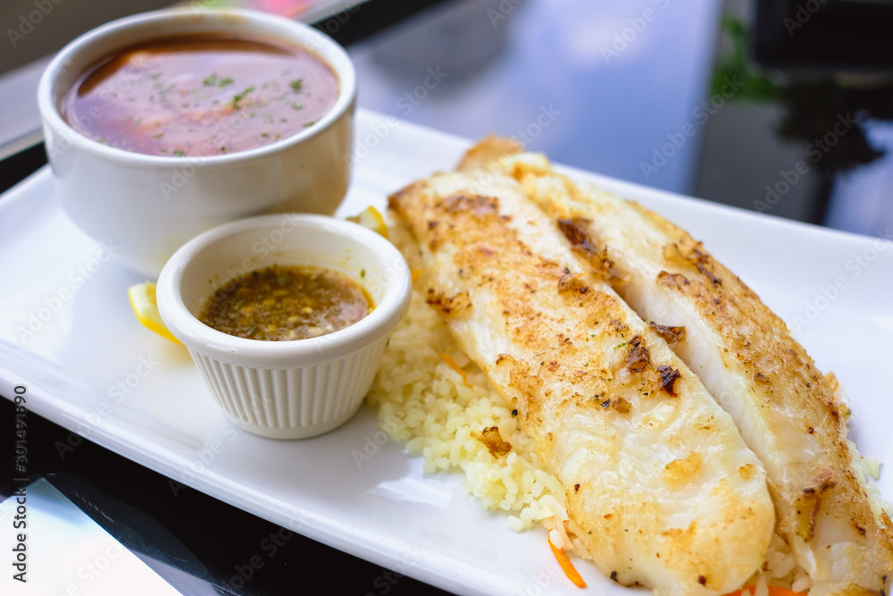 Grilled Pangasius with rice and garlic sauce, serve with mash potato. Grilled Pangasius with rice and garlic sauce, serve with mash potato.