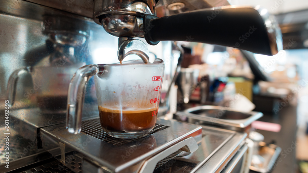 Coffee in measuring cup on a coffee machine Coffee in measuring cup on a coffee machine