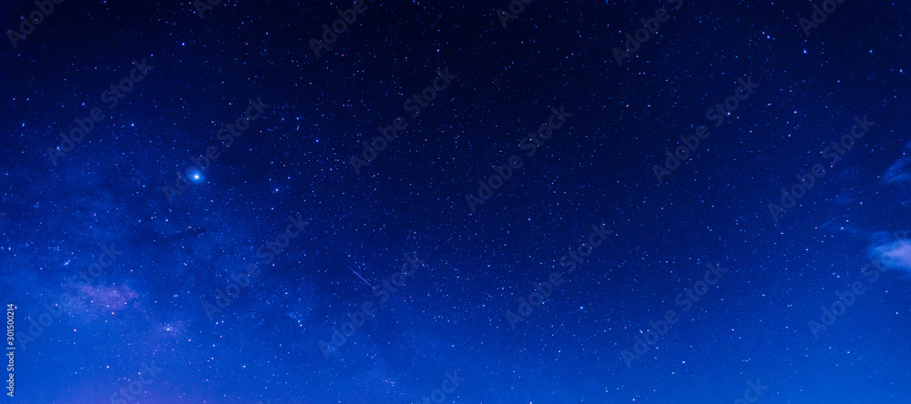 Panorama blue night sky milky way and star on dark background.Universe filled, nebula and galaxy with noise and grain.Photo by long exposure and select white balance.Dark night sky.