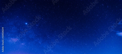 Fototapeta Naklejka Na Ścianę i Meble -  Panorama blue night sky milky way and star on dark background.Universe filled, nebula and galaxy with noise and grain.Photo by long exposure and select white balance.Dark night sky.