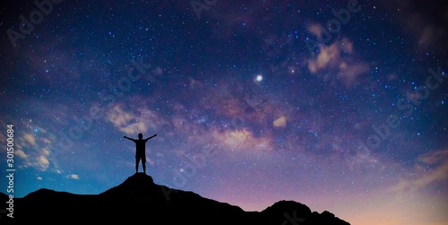 Traveler Man Silhouette Stand Top Mountain.Panorama blue night sky milky way and star on dark background.Universe filled , nebula and galaxy with noise and grain. photo