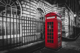 Traditional and iconic old red telephone box in London UK, isolated by color saturation.