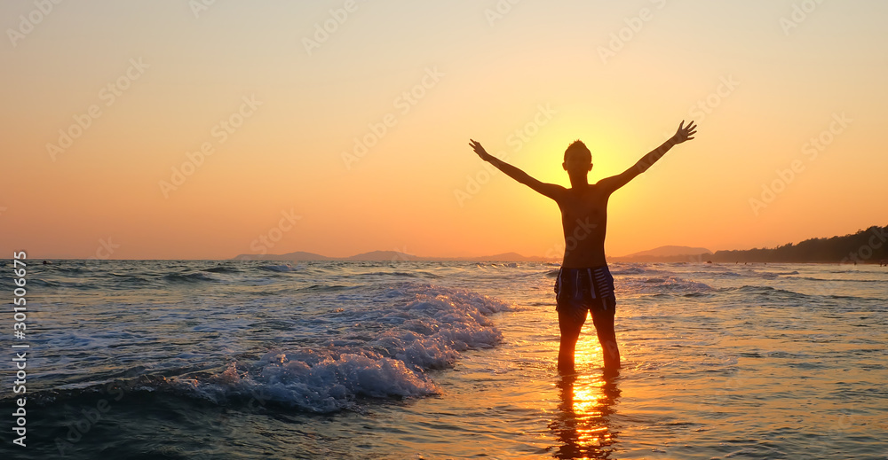 A silhouette of a person relaxing on the sea.Happiness after completion of work.sunset and sunrise.
