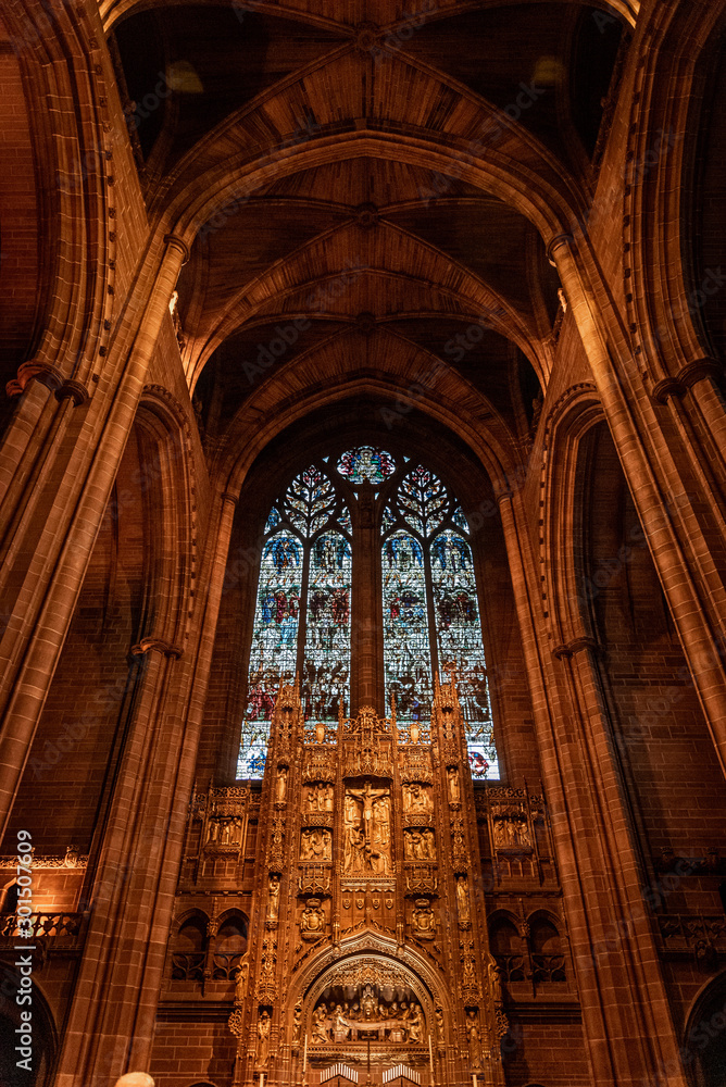 Fototapeta premium LIVERPOOL, ENGLAND, DECEMBER 27, 2018: Magnificent stained glass from interior of the Church of England Anglican Cathedral of the Diocese of Liverpool with biblical sculptures of jesus christ.