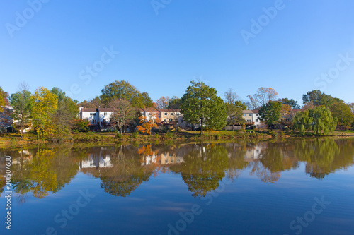 Suburban neighborhood of Falls Church in autumn near water in Virginia, USA. Colorful landscape with deciduous trees in fall.