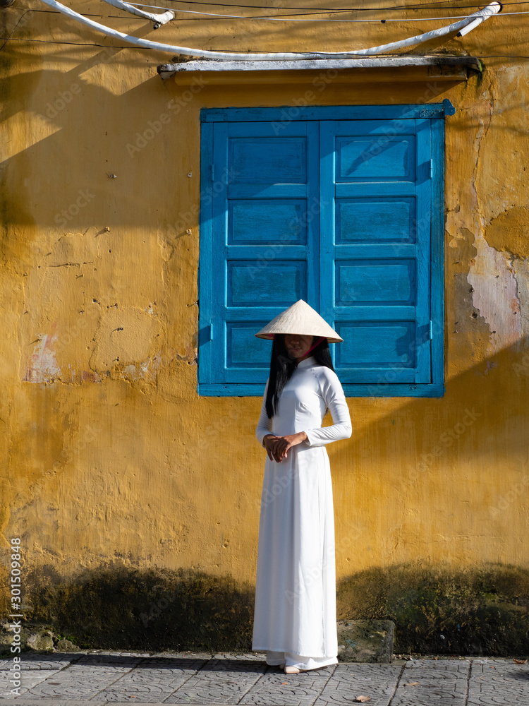 Young Vietnamese Woman in a White Ao Dai or Tunic with Pants