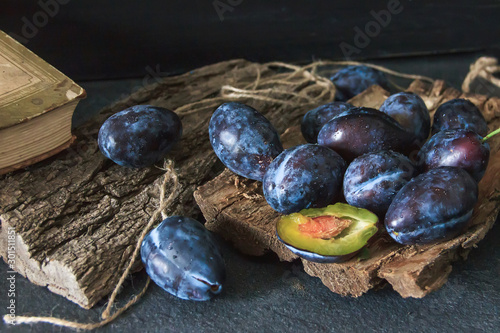 Garden plums on the table. Autumn harvest. Blue plums. Fresh plums on a wooden surface. Fresh plums on a wooden table background. Food Photo