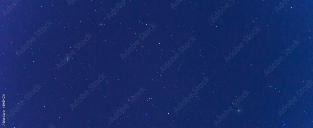 Obraz premium Panorama blue night sky milky way and star on dark background.Universe filled with stars nebula and galaxy with noise and grain.Photo by long exposure and select white balance.Dark night sky.