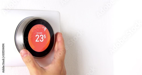 4k Smart Thermostat with a someone warning up the temperature photo