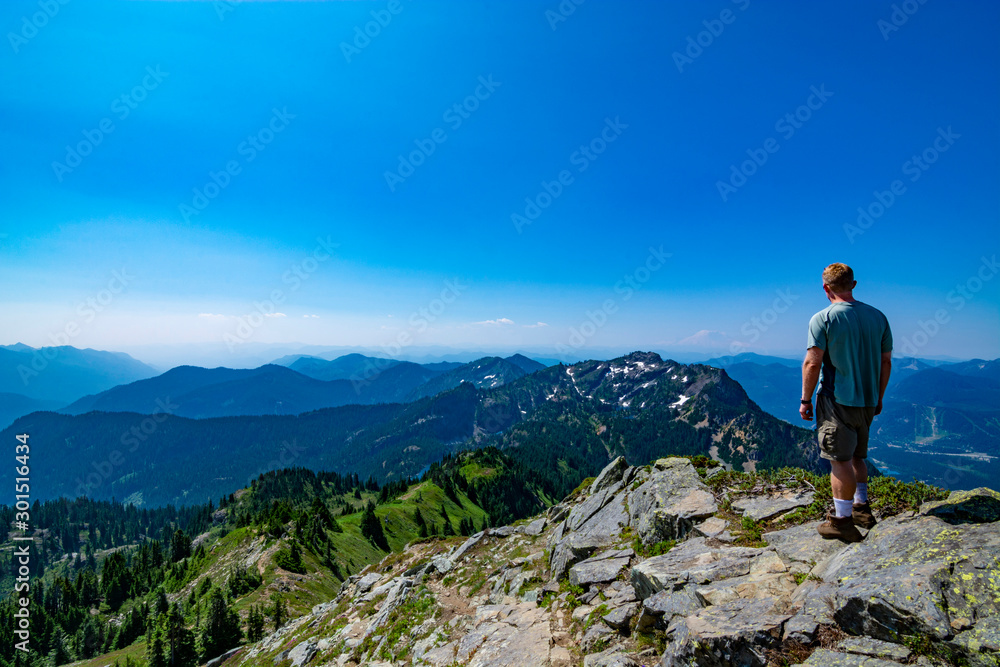 Naklejka premium Adventurous man standing on top of a mountain.