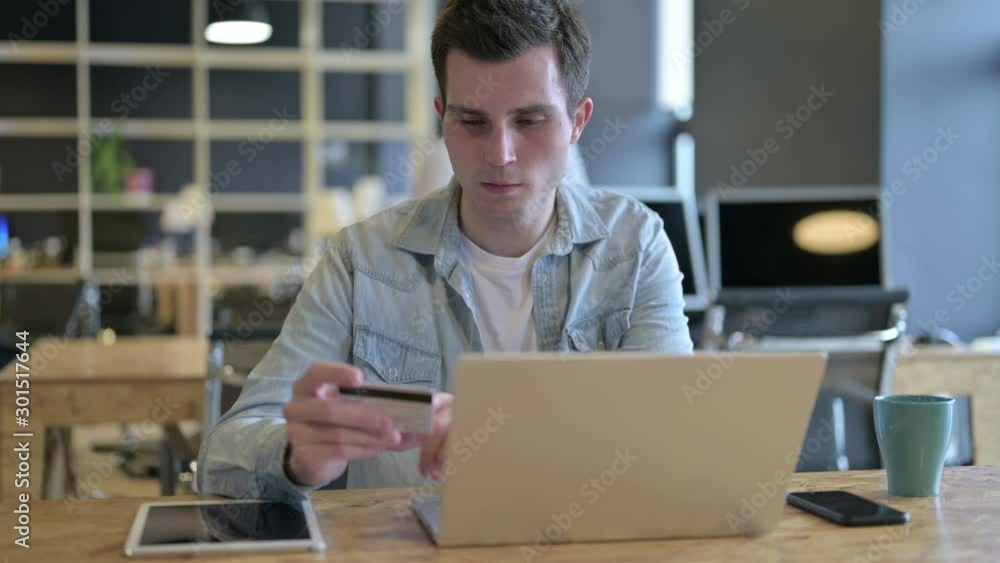 Young Designer Celebrating Successful Online Payment on Laptop Young Designer Celebrating Successful Online Payment on Laptop