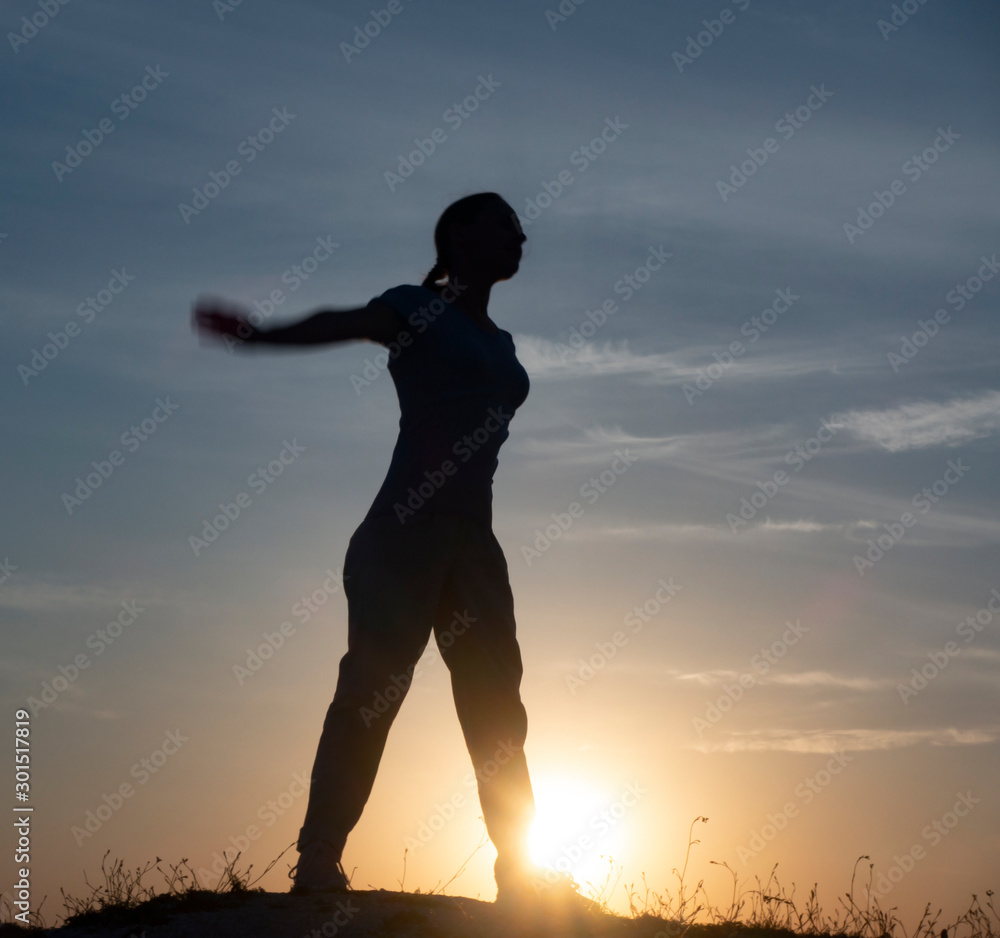 Fototapeta premium Young woman is practicing yoga in natarajasana pose at mountain lake