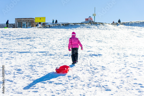 Little girl sledding at Sierra Nevada ski resort.
