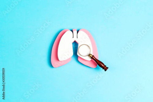 Prevention of pulmonary disease. Lung symbol with magnifier on a blue background.