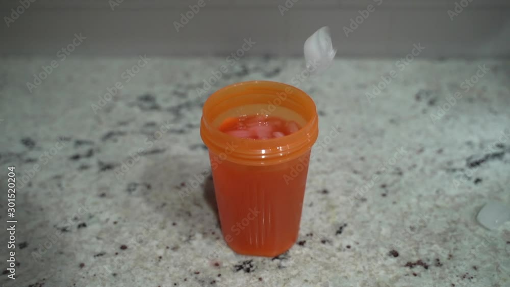 Slow motion: Ice cubes dropping into a pre-workout drink mixer creating a splash Slow motion: Ice cubes dropping into a pre-workout drink mixer creating a splash