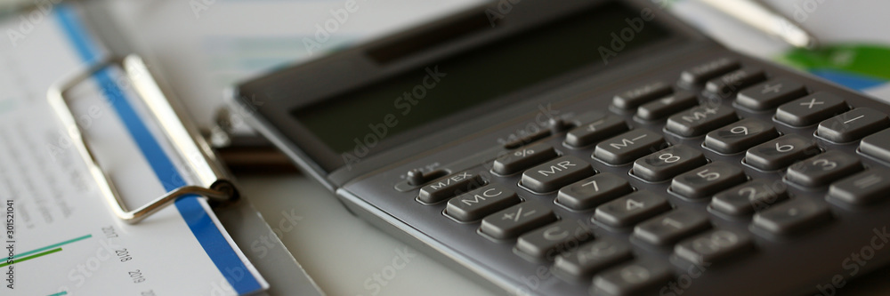 Silver calculator with gray keyboard is lying Silver calculator with gray keyboard is lying
