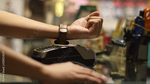 Young man using smart watch contactless payment in shop