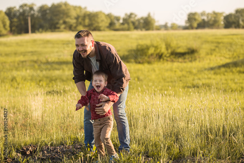 Father's day. Happy family Dad and toddler son playing and laughing on nature at sunset