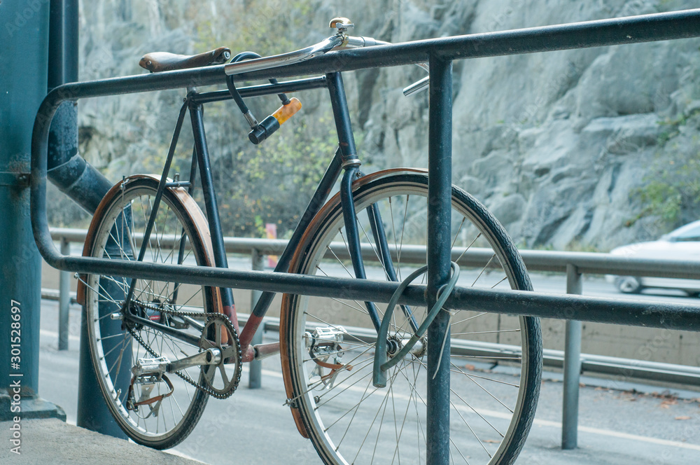Old road bike attached to the fence next to the highway. Old road bike attached to the fence next to the highway.