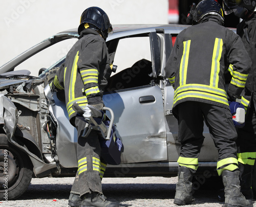 team of firefighters opens the damaged car