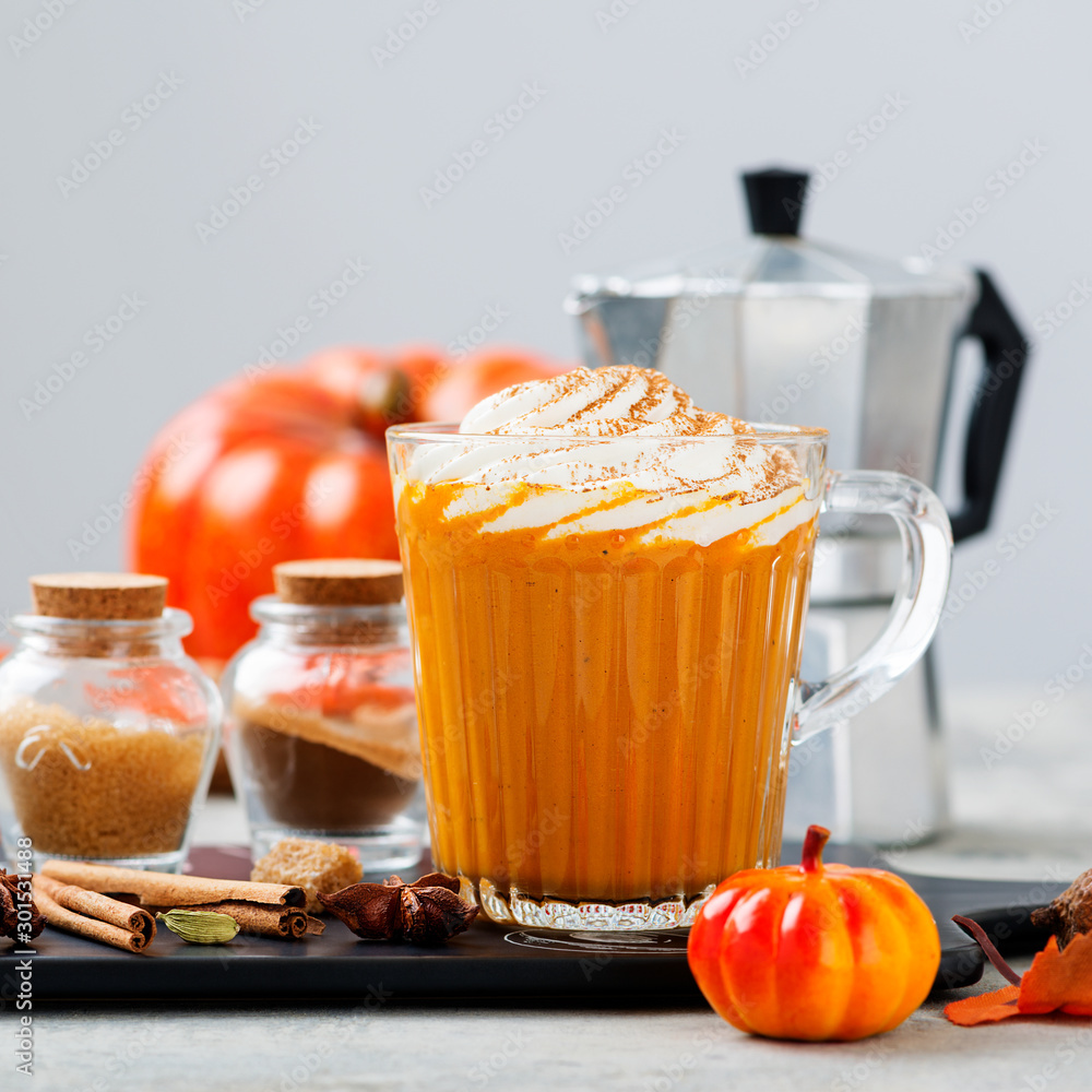 Pumpkin spice latte in a glass mug with cinnamon and nutmeg . Pumpkin spice latte in a glass mug with cinnamon and nutmeg .
