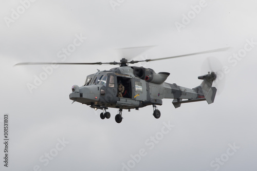 Lynx army helicopter flying with door open and blurred rotors
