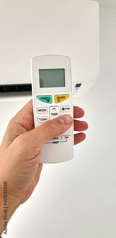 Modern airconditioner unit with a hand holding a remote. Modern airconditioner unit with a hand holding a remote.