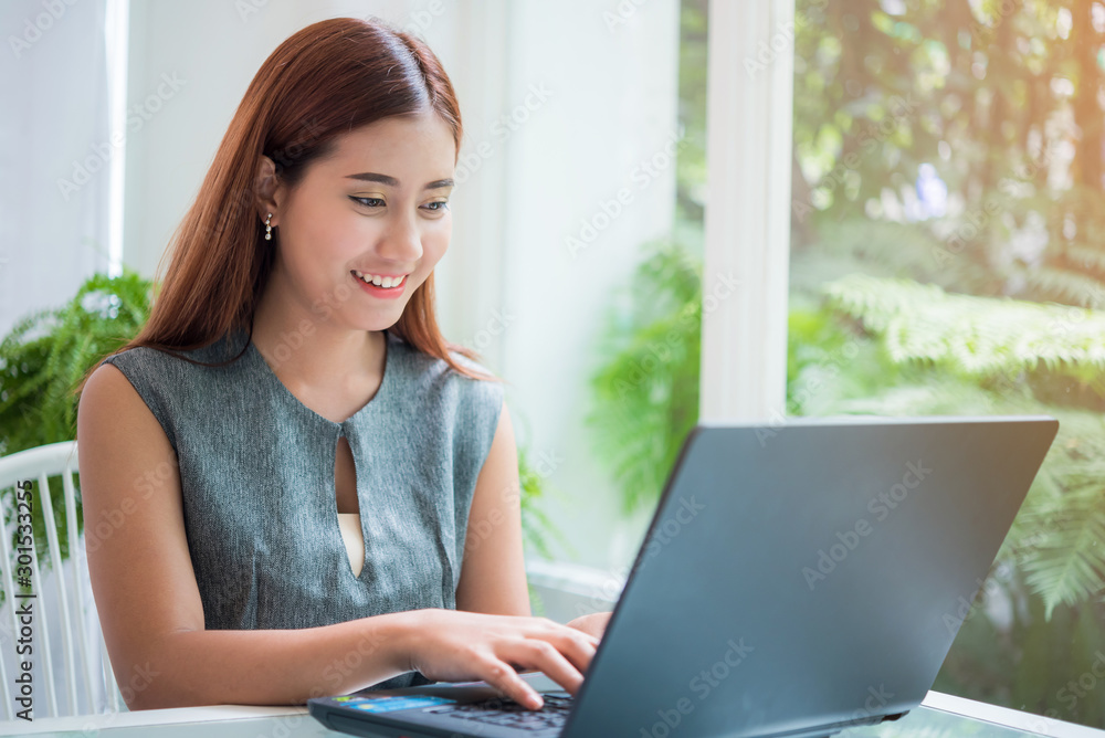 Happy asian business woman working with laptop computer at coffee shop in the morning Happy asian business woman working with laptop computer at coffee shop in the morning
