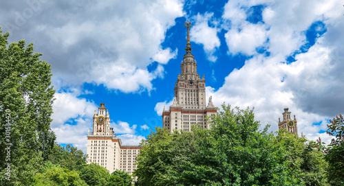 Summer campus of famous Russian university with green trees under blue cloudy sky in Moscow