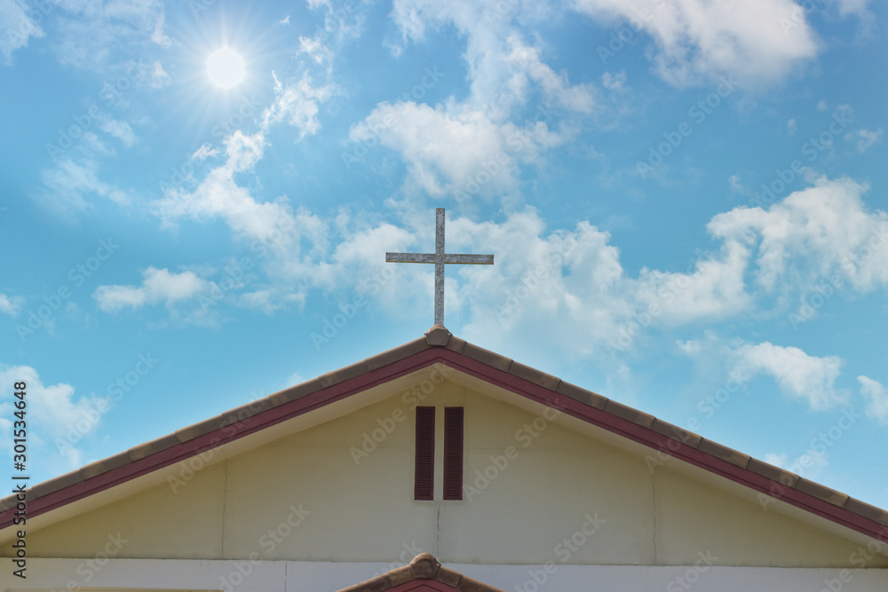 Wooden Christian cross on church over blue sky background.