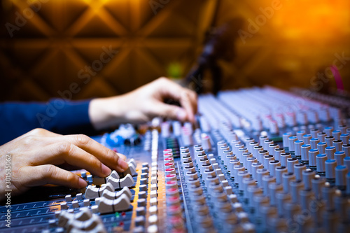 Fotografie music producer, sound engineer hands working on audio mixing console on recording broadcasting studio