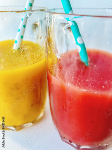 Two glasses of fresh juice. Two colorful fruit shakes. Summer and tropical smoothies. Cold blended drinks, fruit smoothie.