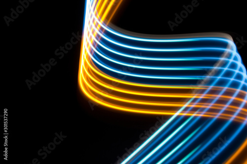 Yellow and blue light curve lines on a black background .