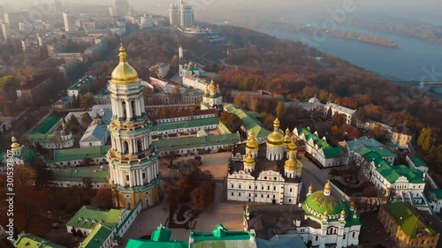 Bell tower Kiev Pechersk Monastery on Dnieper shore from drone above. Aerial view architecture Kiev Pechersky Monastery. Kyiv-Pechersk Lavra on a hill on the banks of Dnipro river. Aerial view video. photo