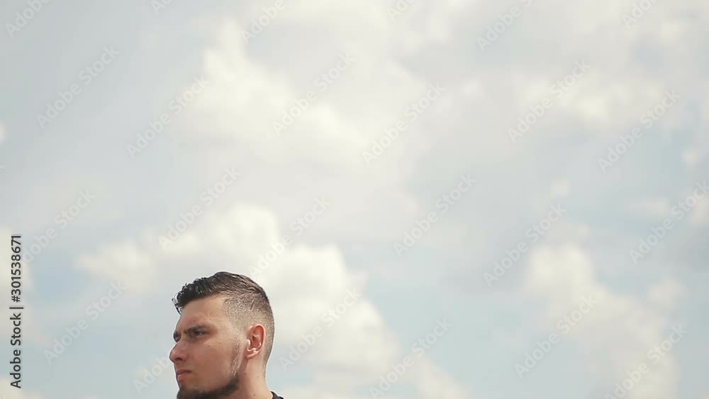 Handsome, young man with a beard in a black T-shirt demonstrates mastery with nunchaku outdoors. Handsome, young man with a beard in a black T-shirt demonstrates mastery with nunchaku outdoors.